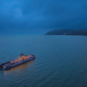 Fénykomp az esti Balaton vizén